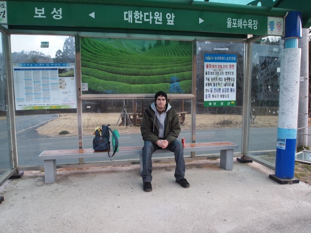 Alex waits at the bus stop